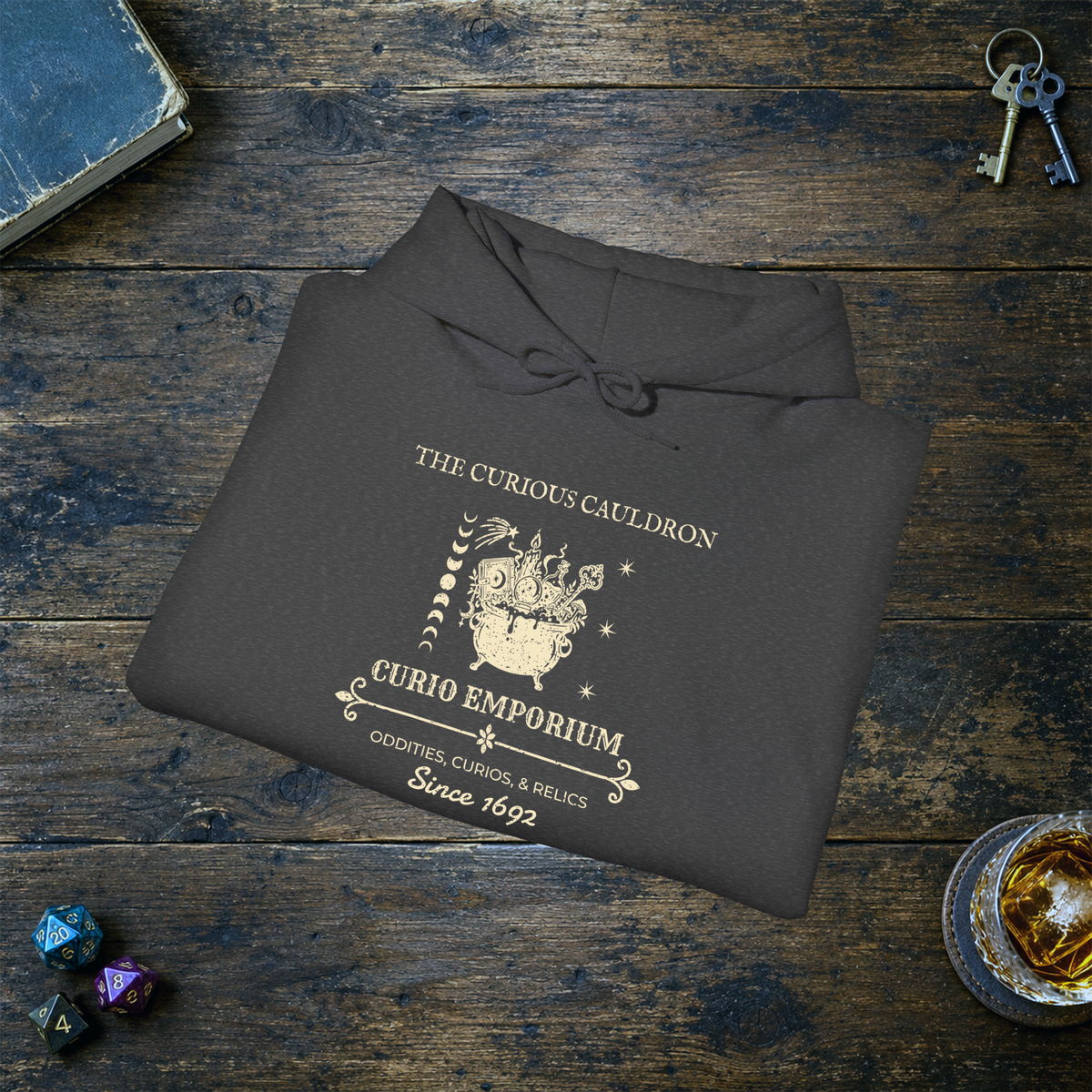 The Curious Cauldron hoodie in Dark Heather, folded mockup