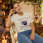 The Curious Cauldron graphic tee on seated woman