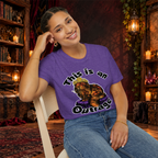 This Is an Outrage graphic T-shirt modeled by a seated woman