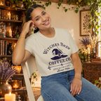Witches Brew Coffee Co. graphic tee on seated woman